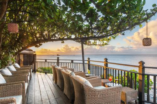a deck with chairs and a view of the ocean at Cap Maison Resort & Spa in Cap Estate