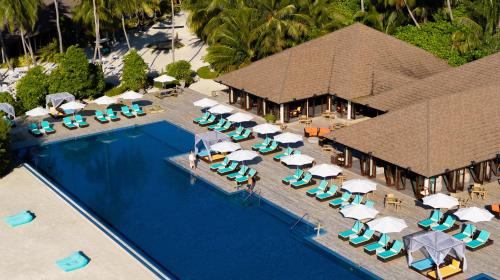 an aerial view of a resort swimming pool with chairs and umbrellas at Atmosphere Kanifushi - Premium All Inclusive with Free Transfers in Lhaviyani Atoll