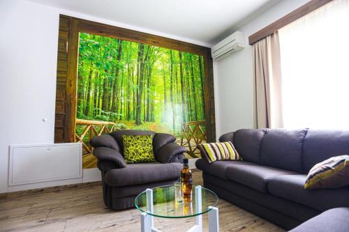 a living room with two couches and a forest mural at Holiday Home Melone in Lećevica