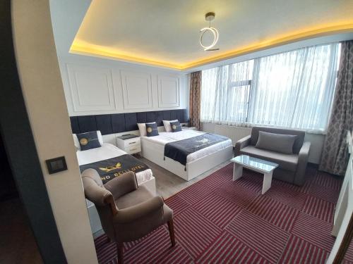 a bedroom with a bed and a couch and a chair at GRAND BELLİ OTEL in Altındağ