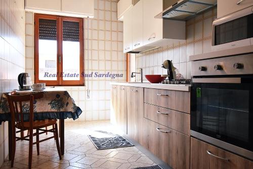 a kitchen with wooden cabinets and a table in it at Casa Elena 1 in Pula
