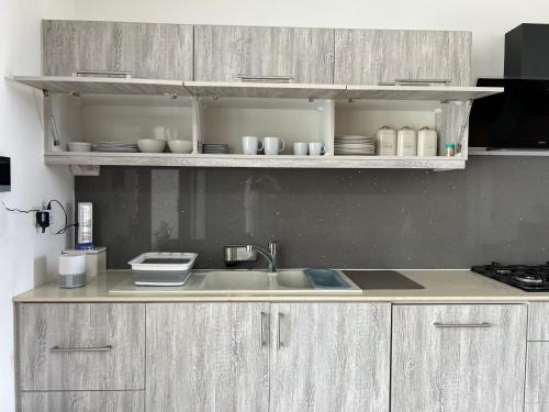 a kitchen with wooden cabinets and a sink at Seascape Modern Accomodation Near CLUB MED ALBION in Albion