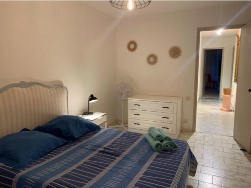 une chambre avec un lit avec des draps bleus et une commode dans l'établissement ANTIBES appartement 2 chambres, à Antibes
