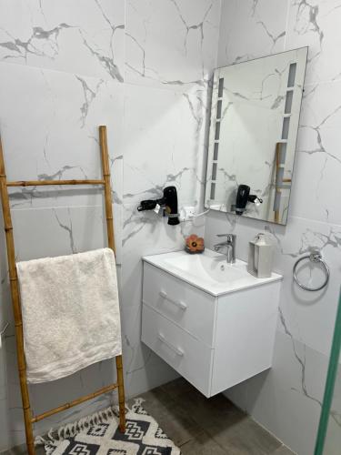 a white bathroom with a sink and a mirror at Seascape Modern Accomodation Near CLUB MED ALBION in Albion