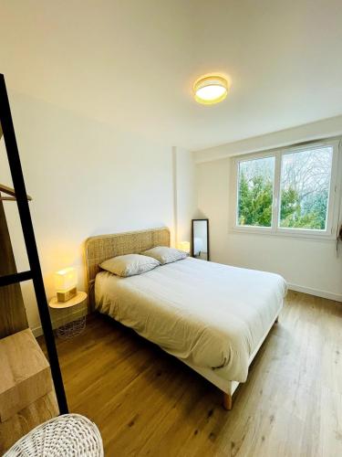 une chambre avec un lit et deux fenêtres dans l'établissement Le Jamot - Proche ville, à La Rochelle