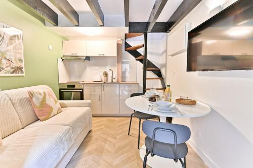 un salon avec un canapé et une table et une cuisine dans l'établissement Maisonette 5 minutes from Paris - Levallois - II, à Levallois-Perret