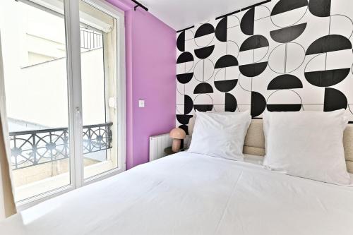 - une chambre avec un lit blanc et un mur noir et blanc dans l'établissement Maisonette 5 minutes from Paris - Levallois - II, à Levallois-Perret