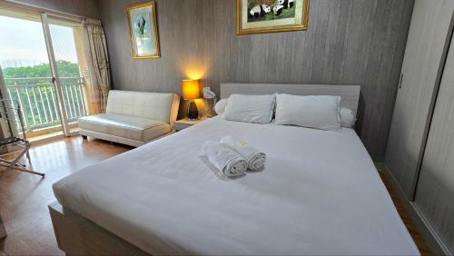 贝克西Trivium Terrace Apartment Lippo Cikarang EJIP -Min Stay 3 Nights-的卧室里有一张白色的大床，床上放着毛巾