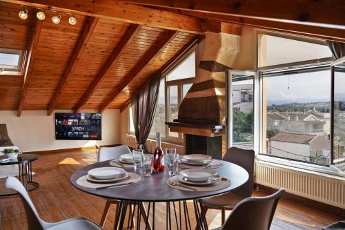 Un comedor con mesa y sillas y ventanas. en Marios Family House 2, en Corfú