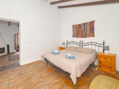 ein Schlafzimmer mit einem Bett mit zwei blauen Kissen darauf in der Unterkunft Cubo's Nueva House Town Center in Alhaurín el Grande