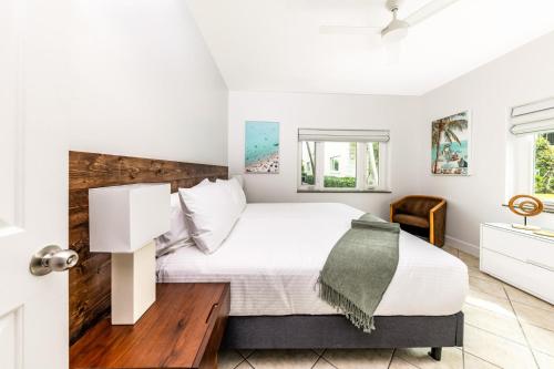 a bedroom with a white bed with a wooden headboard at 2 Bdrm Garden Marina View at The Yacht Club C4 in Providenciales