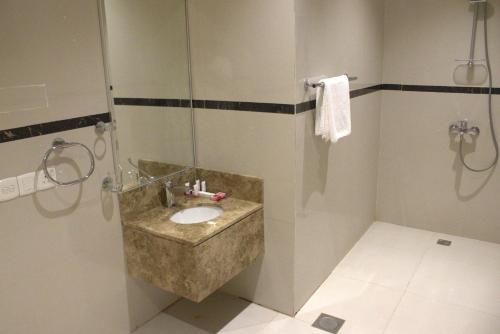 リヤドにあるسمت ان النرجس للشقق المخدومة - Samt Inn Al Narjis Serviced Apartmentsのバスルーム(石造りの洗面台、シャワー付)