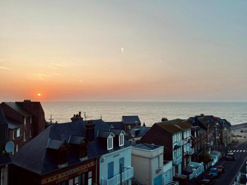 - une vue sur l'océan depuis une ville au coucher du soleil dans l'établissement Vue sur Mer - app cosy à Ault, à Ault
