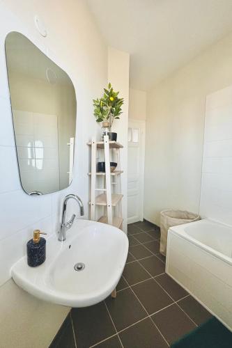une salle de bain avec un lavabo, un miroir et une baignoire dans l'établissement Vue sur Mer - app cosy à Ault, à Ault