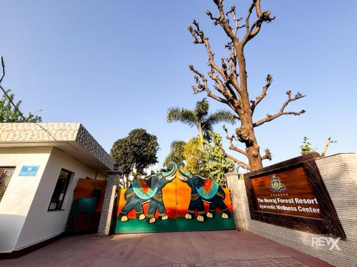 a building with a mural of elephants on it at The Neeraj River Forest Resort Ayurvedic Wellness Center in Rishīkesh