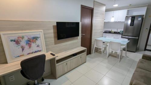 a kitchen with a television and a table with chairs at Beach Class Convention - Flats em Boa Viagem por Yolo in Recife