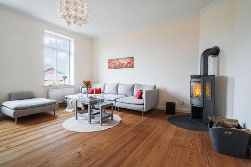 a living room with a couch and a fireplace at Ferienwohnung Gut Hardesby in Sörup