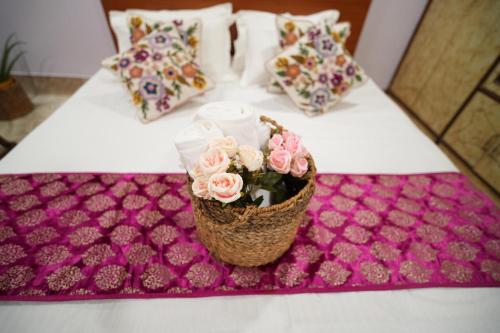 a table with a basket of pink flowers on it at Brij Inn Guwahati in Guwahati