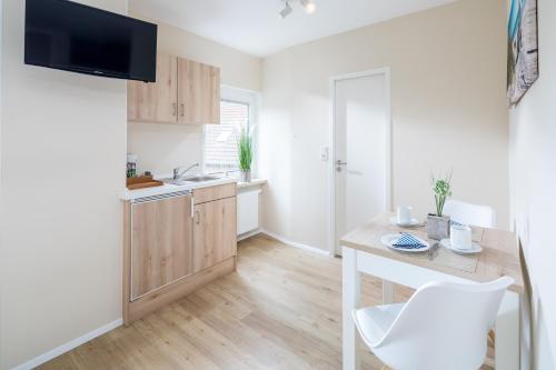 a kitchen with a table and a counter top at Pension Sonnenstrand in Norden