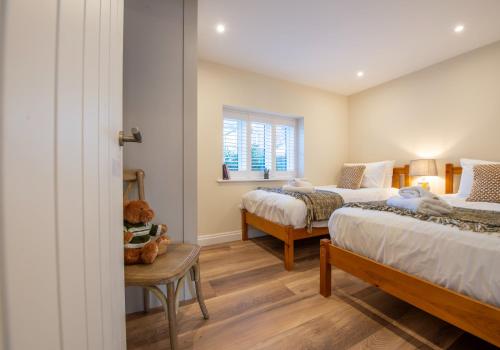 a bedroom with two beds and a window at Scallop Lodge Lytham in Lytham St Annes