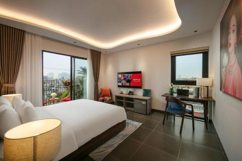 a hotel room with a bed and a desk with a computer at Hanoi Riverview Boutique Hotel & Apartment in Hanoi