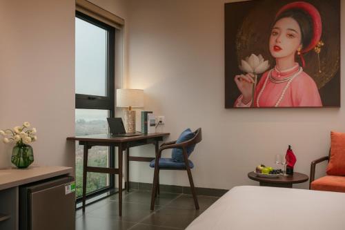 a room with a desk and a painting of a woman at Hanoi Riverview Boutique Hotel & Apartment in Hanoi