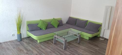 a living room with a green couch and a table at FewoAltstadt76 in Gmünd