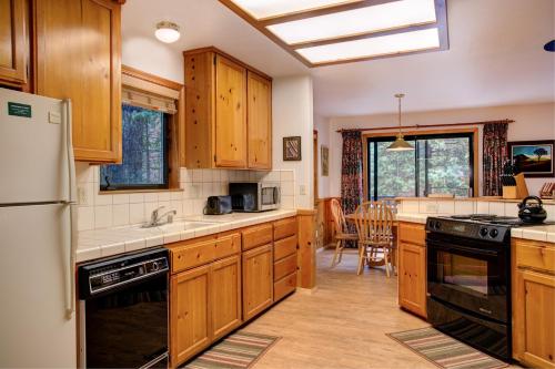 a kitchen with wooden cabinets and a stove top oven at Cecil's Cabin in Wawona