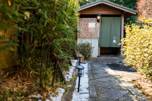 a building with a green door and a parking meter at Pension Yufuin in Yufuin