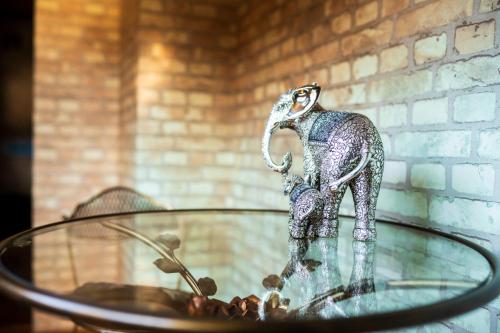 a metal elephant statue sitting on a glass table at Pension Yufuin in Yufuin