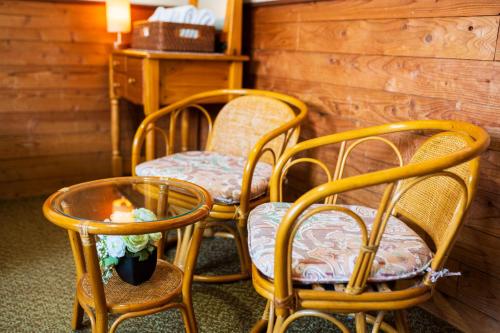 a group of chairs and a table with flowers on it at Pension Yufuin in Yufuin