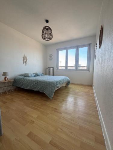 une chambre avec un lit et un parquet dans l'établissement Face port proche nausicaa avec parking privé gratuit, à Boulogne-sur-Mer