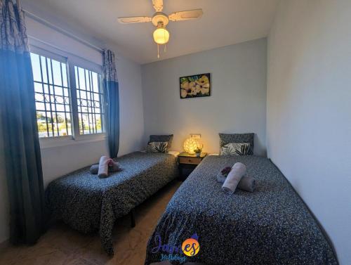 una camera da letto con due letti e una finestra di Traditional 3 Bed Quad House Playa Flamenca PF5 a Orihuela