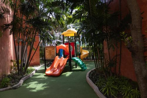 a playground with a slide in a garden at Seven Seas Condo Resort Jomtien in Jomtien Beach