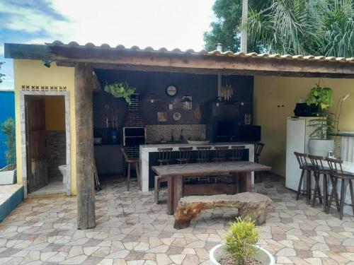 a patio with a table and a kitchen with a refrigerator at Pousada Rua 35 Na Villa Verde Buzios Rj in Buzios