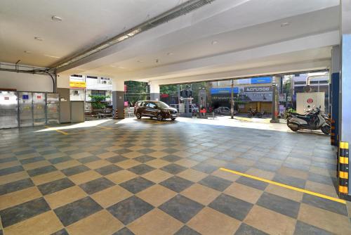 a garage with a car parked in a car dealership at Eka Lyf Inn in Coimbatore