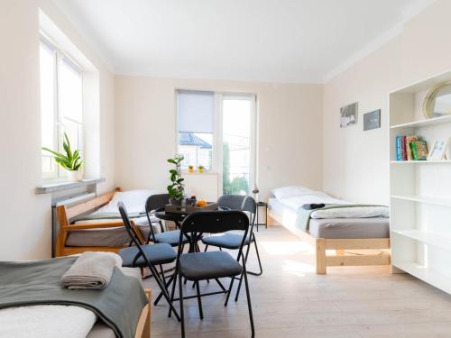 a room with beds and a table and chairs at Noclegi M21 in Białystok