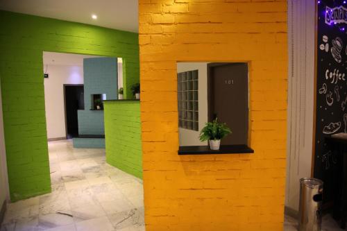 a yellow and green wall in a room with a potted plant at Shanghai Fish Inn Bund in Shanghai
