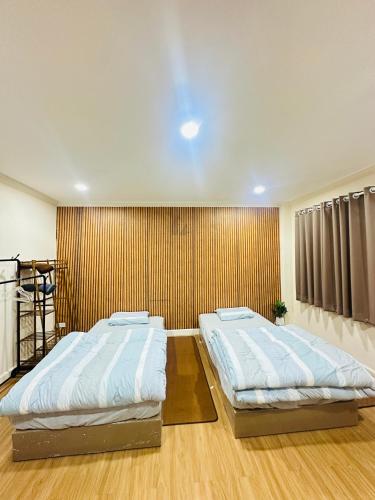 two beds in a room with a wall at Dedbaicha cafe & Hostel Phuket old town in Phuket