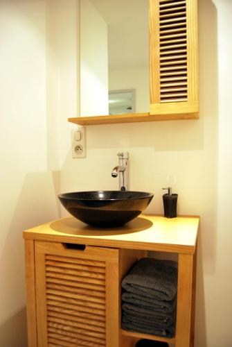 La salle de bains est pourvue d'un lavabo noir sur un comptoir. dans l'établissement A 5mn à pieds du centre historique de Sarlat, à Sarlat-la-Canéda