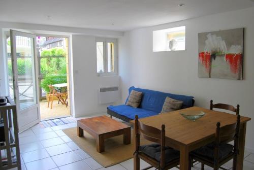 un salon avec une table et un canapé bleu dans l'établissement A 5mn à pieds du centre historique de Sarlat, à Sarlat-la-Canéda