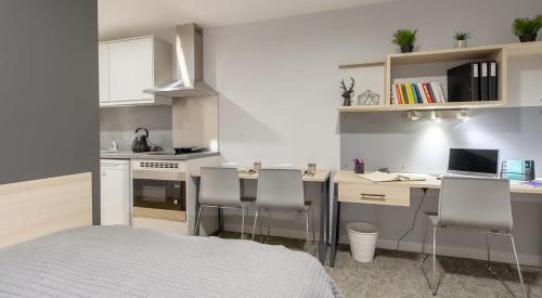 a kitchen with a desk with chairs and a laptop at For Students Only Straits Manor in Sheffield in Sheffield