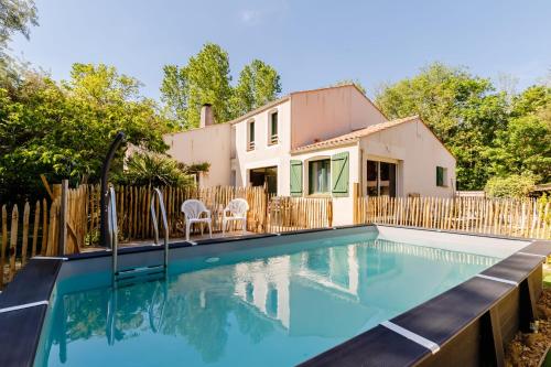 une piscine devant une maison dans l'établissement Villa L'Eau Vive, à Saint-Jean-de-Monts