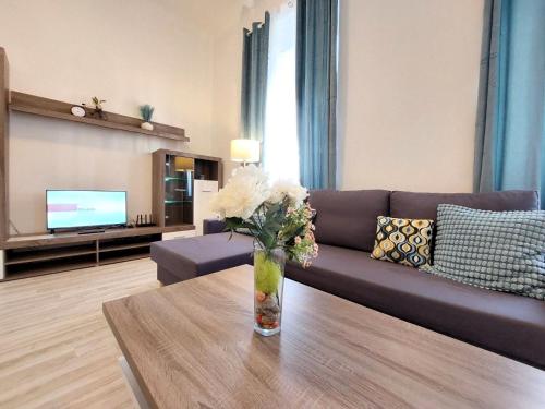 a living room with a couch and a vase of flowers on a table at Apartment ČSA #1 in the Historic Center Hradec Králové in Hradec Králové