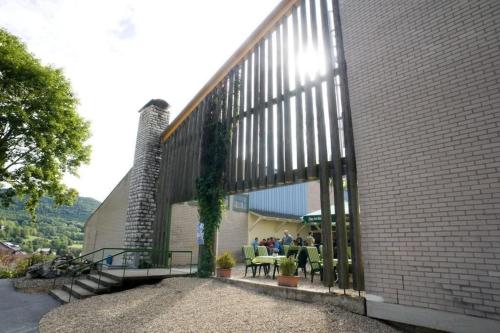 a building with people sitting at tables on a patio at Sporthotel Streitberg in Streitberg