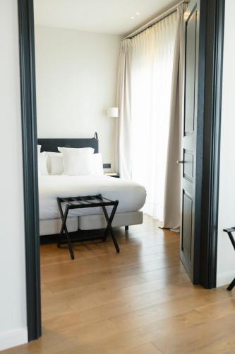 a bedroom with a bed and a table next to a door at Hotel Boutique Sidonia in Jerez de la Frontera