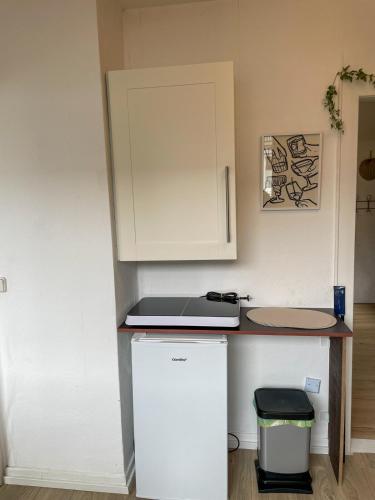 a small kitchen with a counter and a refrigerator at Charmantes Altbauflair Nordhorn in Nordhorn