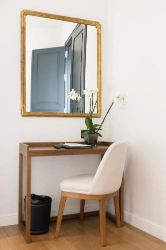a mirror on a desk with a chair and a mirror at Hotel Boutique Sidonia in Jerez de la Frontera