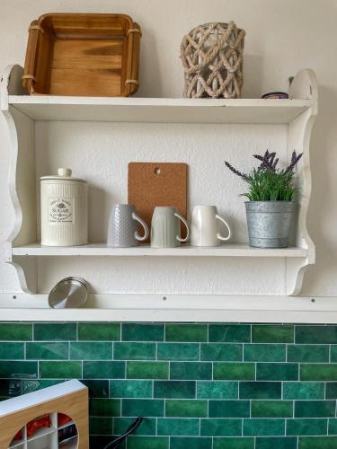 a kitchen with green tile on the wall at Charmantes Altbauflair Nordhorn in Nordhorn