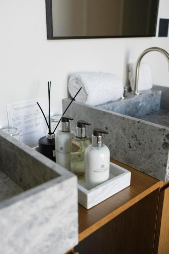 a bathroom sink with two soap bottles on a counter at Hotel Boutique Sidonia in Jerez de la Frontera